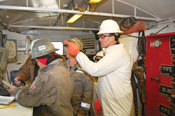 Fig. 1. Congressman Pete Olson (white coat) gets some instruction on operations from rig personnel in the top doghouse of a Nomac Drilling, LLC, rig. Nomac is an affiliate of Chesapeake Oilfield Services, which is a subsidiary of Chesapeake Energy Corporation. Photo courtesy of Office of Rep. Pete Olson.