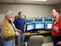Fig. 2. Swift Energy V.P. for Production Randy Bailey (left) gestures while explaining the functions of his firm’s Drilling Operations Center to Congressman Pete Olson (right), while Swift field engineer John Mogk looks on.