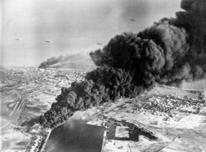 Smoke rises from oil tanks beside the Suez Canal, hit during the Anglo-French assault on Port Said on Nov. 5, 1956. Photo: Imperial War Museums.