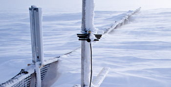 Fig. 1. An experimental snow barrier and monitoring devices with accumulated snow in March 2010.