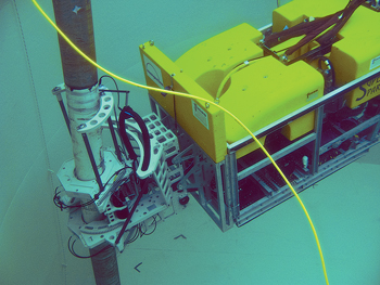 Fig. 3. Fugro and Innospection’s riser inspection system involves the use of an ROV with a clamp-on electromagnetic scanner that detects localized material defects, such as cracks and corrosion, as well as material fatigue and general wall loss. This enhanced photo shows the system operating in a test tank.