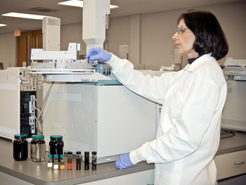 Linda Clancy of Weatherford Laaboratories loads an oil sample into the auto-sampler tray of an Agilent-6890 Gas Chromatograph. The instrument can readily separate an oil into ~1000 components, each of which can serve as a "natual tracer" for geochemical allocation of commingled oil production. Linda Clancy of Weatherford Laaboratories loads an oil sample into the auto-sampler tray of an Agilent-6890 Gas Chromatograph. The instrument can readily separate an oil into ~1000 components, each of which can serve as a "natual tracer" for geochemical allocation of commingled oil production.